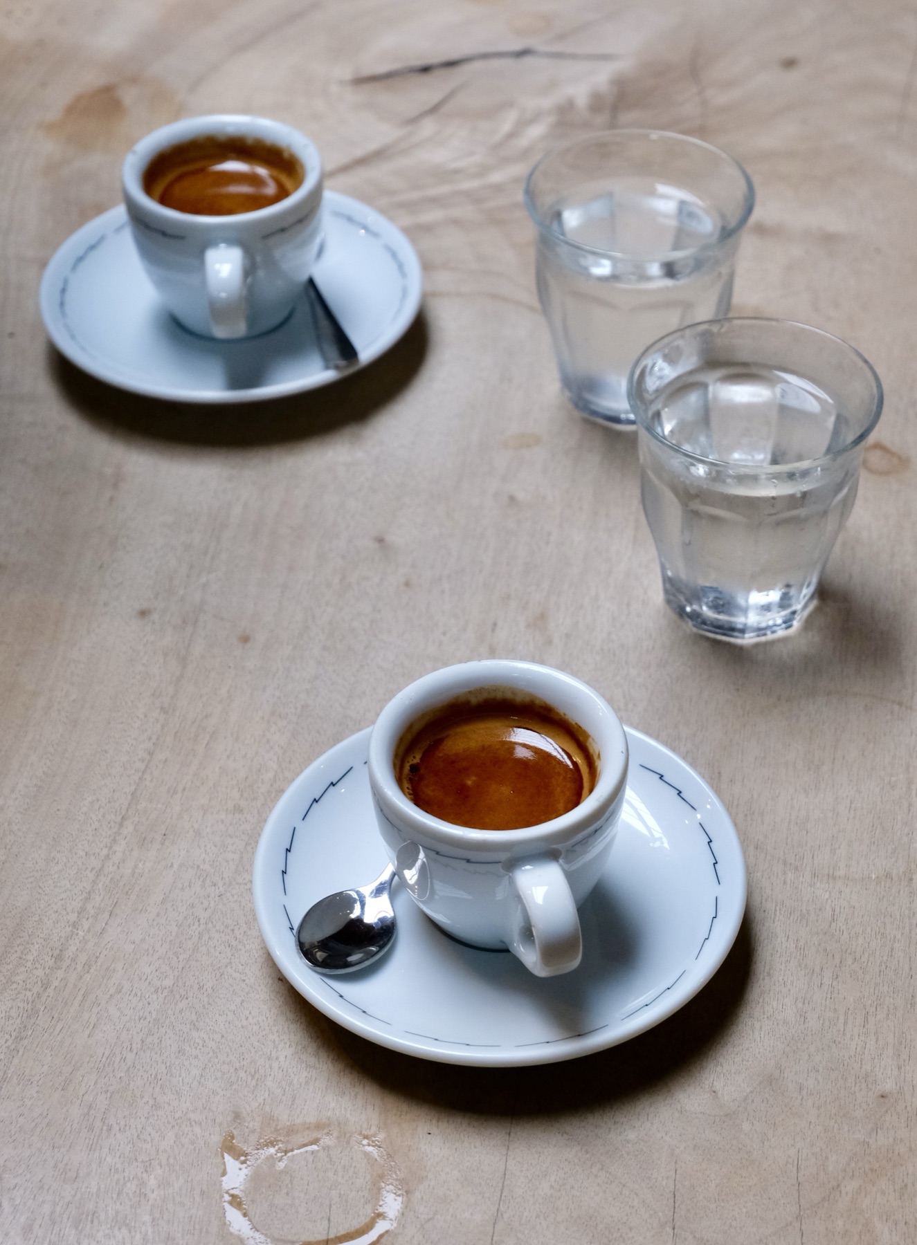 Two espresso cups and glasses of water
